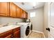 Well-lit laundry room featuring a modern washer and dryer, with lots of cabinet storage and a sink at 4968 Montvale Dr, Highlands Ranch, CO 80130