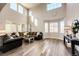 Spacious living room with vaulted ceilings, large windows, and modern wood-look floors at 4968 Montvale Dr, Highlands Ranch, CO 80130