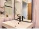 Close up of a modern bathroom sink with stylish faucet and mirror and light pink accent wall at 15912 E Dakota Pl # C, Aurora, CO 80017