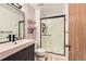 Modern bathroom with black matte fixtures, glass enclosed shower, and light wood floors at 15912 E Dakota Pl # C, Aurora, CO 80017