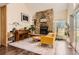 Cozy living room with stone fireplace, piano, yellow sofa and a neutral area rug at 15912 E Dakota Pl # C, Aurora, CO 80017