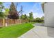Lush backyard with mature trees, a new concrete patio, and a wooden privacy fence at 3193 W 134Th Cir, Broomfield, CO 80020