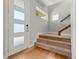 Bright entryway featuring hardwood floors, a modern door with glass panels and carpeted stairs at 5988 N Boston St, Denver, CO 80238