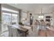 Open-concept dining room with an adjacent kitchen featuring a large sliding glass door and hardwood floors at 1152 Sugarloaf Ln, Erie, CO 80516