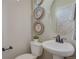 Cozy powder room showcasing elegant wall decor and a pedestal sink with classic faucet at 1152 Sugarloaf Ln, Erie, CO 80516