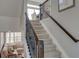 Carpeted staircase with dark wood railing leading to an upper level and cozy seating area at 1152 Sugarloaf Ln, Erie, CO 80516