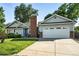 Charming home showcasing a two-car garage and lush lawn, enhanced by a prominent brick chimney at 5193 S Flanders Ln, Centennial, CO 80015