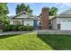 Charming single-story home with a manicured lawn, brick chimney and a welcoming blue front door at 5193 S Flanders Ln, Centennial, CO 80015