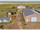 Aerial view of the property featuring multiple storage buildings, trees, and green grass at 47855 E 88Th Ave, Bennett, CO 80102