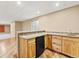 Basement bar area features wood cabinets, a mini fridge, sink, and tile countertops at 47855 E 88Th Ave, Bennett, CO 80102