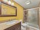 Well-lit bathroom featuring a granite countertop, wood framed mirror, and glass door shower at 47855 E 88Th Ave, Bennett, CO 80102