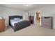 Bedroom with a comfortable bed, dresser, and an open doorway leading to an en-suite bathroom at 47855 E 88Th Ave, Bennett, CO 80102
