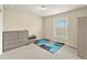 Simple bedroom with neutral walls, plush carpet, a large dresser, and a window offering outdoor views at 47855 E 88Th Ave, Bennett, CO 80102
