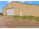 Exterior view of a metal building with a large door and puddles on the ground at 47855 E 88Th Ave, Bennett, CO 80102