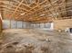 Large garage interior with an open beam ceiling and concrete floors at 47855 E 88Th Ave, Bennett, CO 80102