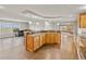 Open kitchen featuring a wrap around bar, ample cabinets, and views of the living area at 47855 E 88Th Ave, Bennett, CO 80102