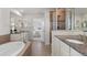 Bright bathroom with a soaking tub, glass shower, and dual sinks with granite countertops at 27596 E Jamison Cir, Aurora, CO 80016