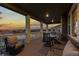 Inviting covered deck with comfortable seating and a table, offering scenic sunset views at 27596 E Jamison Cir, Aurora, CO 80016