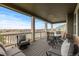 Inviting covered deck with comfortable seating and a table, offering scenic neighborhood views at 27596 E Jamison Cir, Aurora, CO 80016