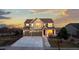 Inviting two-story home featuring a three-car garage, manicured lawn, and charming front porch at 27596 E Jamison Cir, Aurora, CO 80016