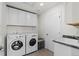 Functional laundry room with a washer, dryer, sink, and plenty of cabinet storage at 27596 E Jamison Cir, Aurora, CO 80016