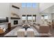 Bright, open living room with a stone fireplace, large windows, and contemporary furnishings, perfect for modern living at 27596 E Jamison Cir, Aurora, CO 80016