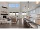Open-concept living space seamlessly connects the living room with a modern kitchen and breakfast bar, bathed in natural light at 27596 E Jamison Cir, Aurora, CO 80016