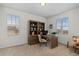 Cozy home office with built-in bookshelves, neutral carpet, and comfortable seating offers a quiet workspace at 27596 E Jamison Cir, Aurora, CO 80016