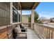 Relaxing covered front porch seating area with stone accents and outdoor cushions at 27596 E Jamison Cir, Aurora, CO 80016