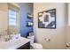 Charming bathroom featuring blue accent wall, modern vanity, framed art and open shelving at 1350 Loraine N Cir, Lafayette, CO 80026