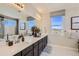 Bathroom featuring a large vanity with double sinks, quartz countertop and a separate bathtub and shower at 1350 Loraine N Cir, Lafayette, CO 80026