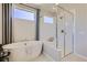 Bright bathroom featuring modern tub and shower with glass enclosure, neutral color palette at 1350 Loraine N Cir, Lafayette, CO 80026