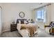 Bright bedroom featuring a large window, cozy bed, nightstand, decorative mirror and comfortable chair at 1350 Loraine N Cir, Lafayette, CO 80026