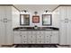 Double vanity bathroom with dark counters and white cabinets at 1708 Creedmoor Ct, Castle Rock, CO 80109