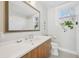 Bright bathroom with a large mirror, vanity, and a view from the window at 2034 Dahlia St # 1, Denver, CO 80207