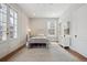 Sunlit bedroom with white metal frame bed, neutral walls, and elegant French doors at 2034 Dahlia St # 1, Denver, CO 80207