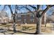 A stately brick apartment building framed by mature trees offering shade and character at 2034 Dahlia St # 1, Denver, CO 80207