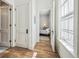 Hallway leading to a sunlit bedroom featuring hardwood floors and white doors at 2034 Dahlia St # 1, Denver, CO 80207