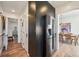 Hallway with hardwood flooring, adjacent to dining room featuring stainless steel refrigerator and modern cabinetry at 2034 Dahlia St # 1, Denver, CO 80207