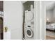 Laundry area with stacked washer and dryer, conveniently located near the bedroom at 2034 Dahlia St # 1, Denver, CO 80207