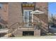 Brick patio with wrought iron furniture and potted plants with seating area at 2034 Dahlia St # 1, Denver, CO 80207