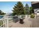 Inviting deck featuring wood flooring, a black steel bench, fire pit, and views of the surrounding trees at 2777 W 106Th Cir, Denver, CO 80234