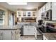 Well-equipped kitchen featuring granite countertops, white cabinetry, modern appliances, and backyard views at 2777 W 106Th Cir, Denver, CO 80234