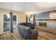 Cozy living room with a brick fireplace, comfortable seating, hardwood floors, and access to the patio at 2777 W 106Th Cir, Denver, CO 80234