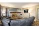 Comfortable living room with a brick fireplace, mounted TV, and a cozy gray sectional sofa at 2777 W 106Th Cir, Denver, CO 80234