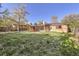 Large, grassy backyard with a patio and mature trees at 7875 Cyd Dr, Denver, CO 80221