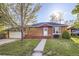 Charming brick home featuring a well-maintained front yard and an inviting front porch at 7875 Cyd Dr, Denver, CO 80221