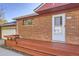 Close-up showcasing the brick facade and wooden front porch of the home at 7875 Cyd Dr, Denver, CO 80221