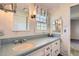 Classic bathroom with wallpaper and blue tile countertop and a double mirrored vanity at 3825 S Peach Way, Denver, CO 80237