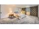 Spacious carpeted bedroom with large window, unique curtains, and bedside table with lamp at 3825 S Peach Way, Denver, CO 80237
